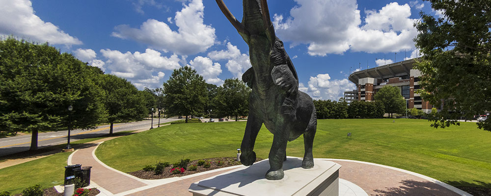 Statue of Tuska with Bryant-Denny Stadium in the background